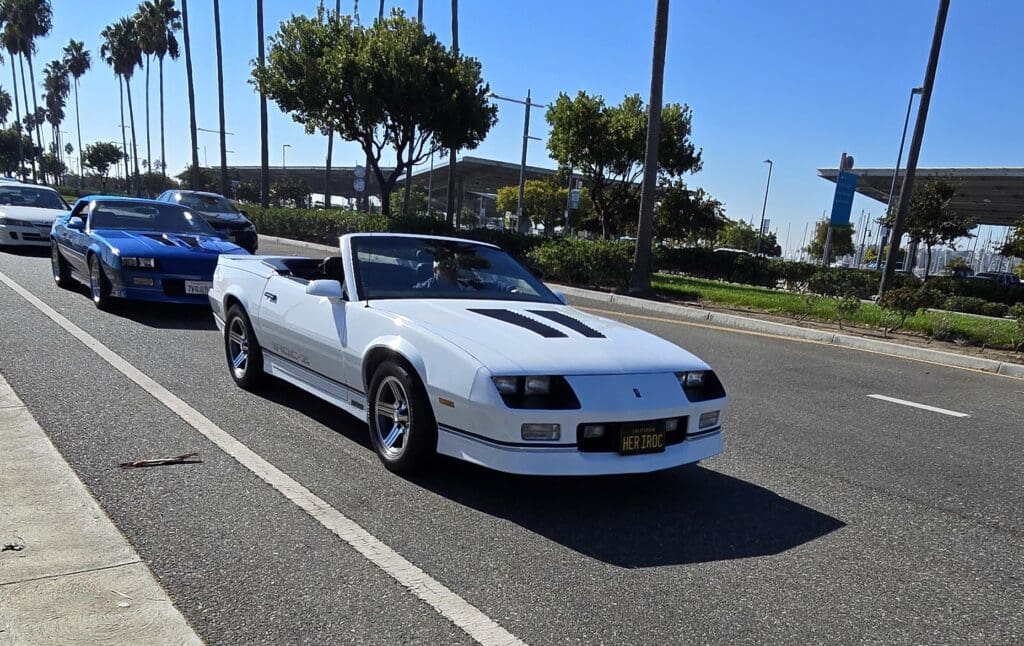 White classic convertible sports car parked on a sunny street.