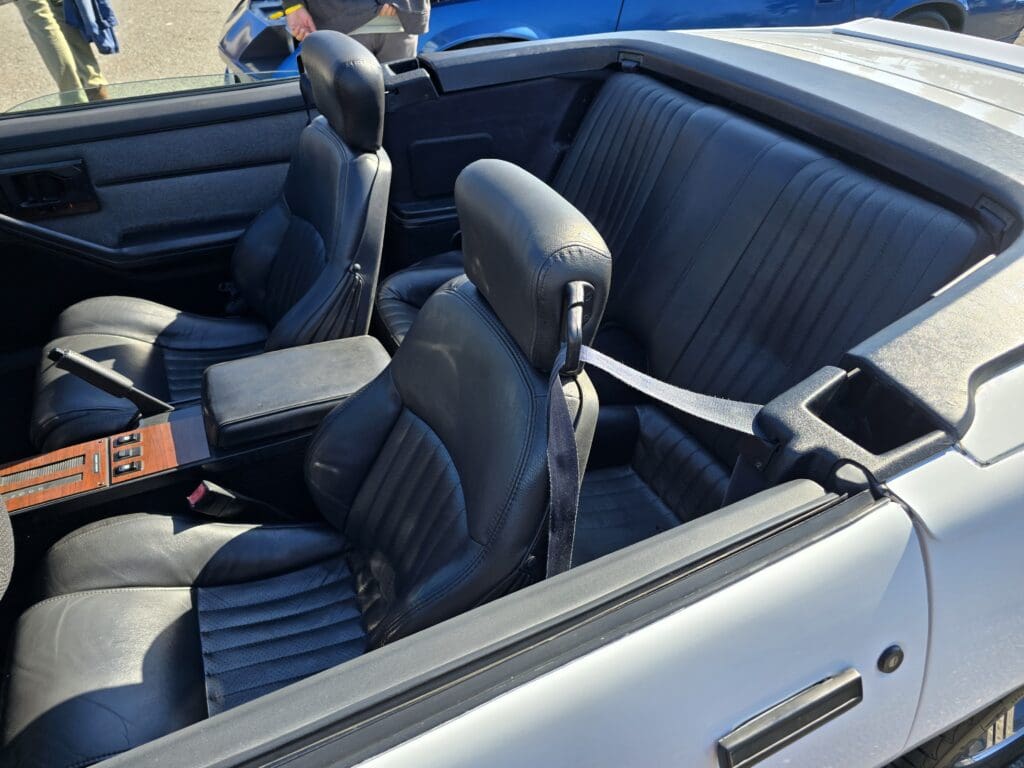 Interior of a classic convertible car with blue leather seats.