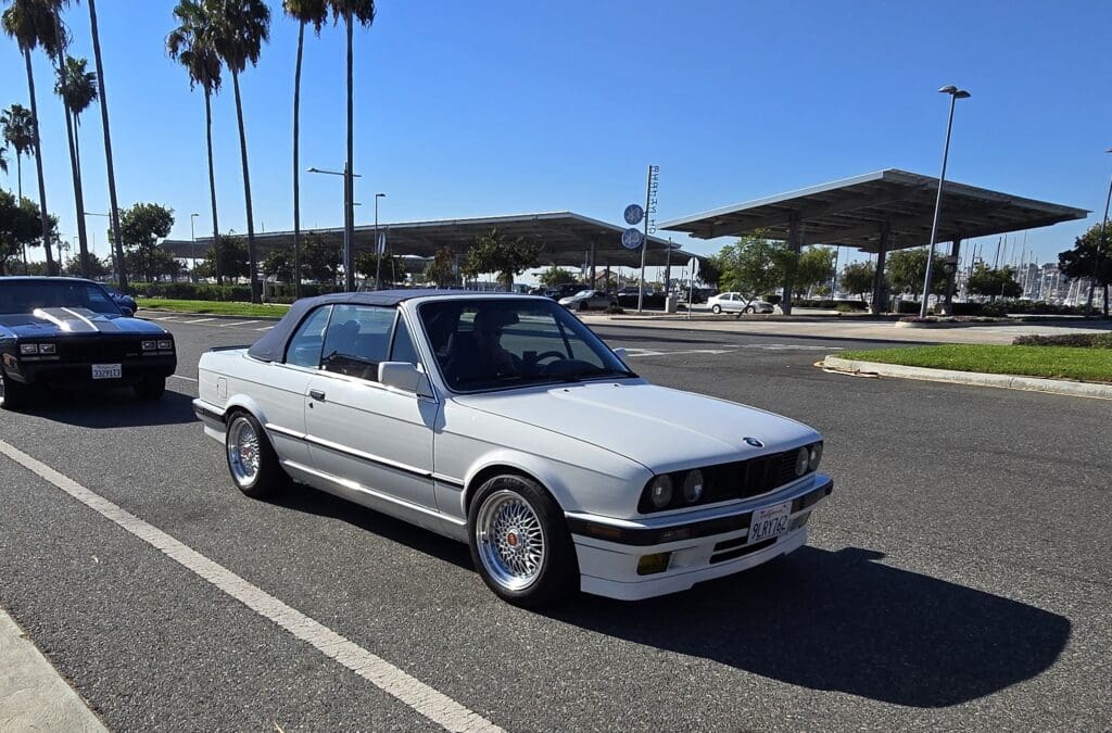 Classic white BMW convertible parked on a sunny day.