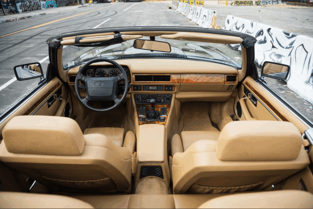 Interior view of a vintage convertible car with tan leather seats.