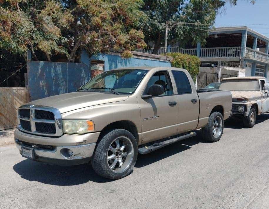 A beige Dodge Ram pickup truck parked outdoors on a sunny day.