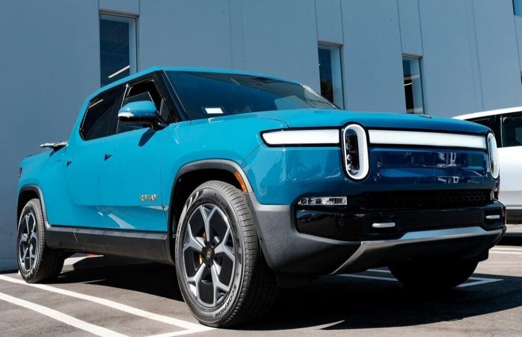 Blue electric SUV parked outdoors in front of a modern building.