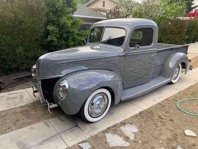 Classic silver vintage pickup truck parked on driveway.