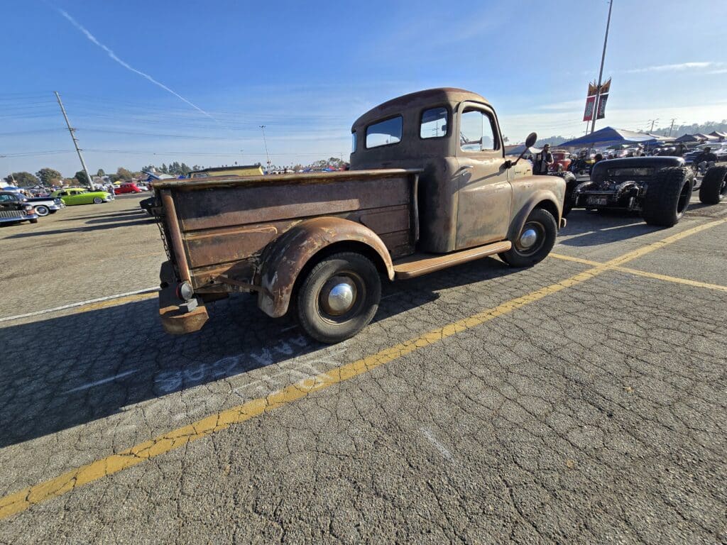 Rustic vintage pickup truck parked in a lot on a sunny day.