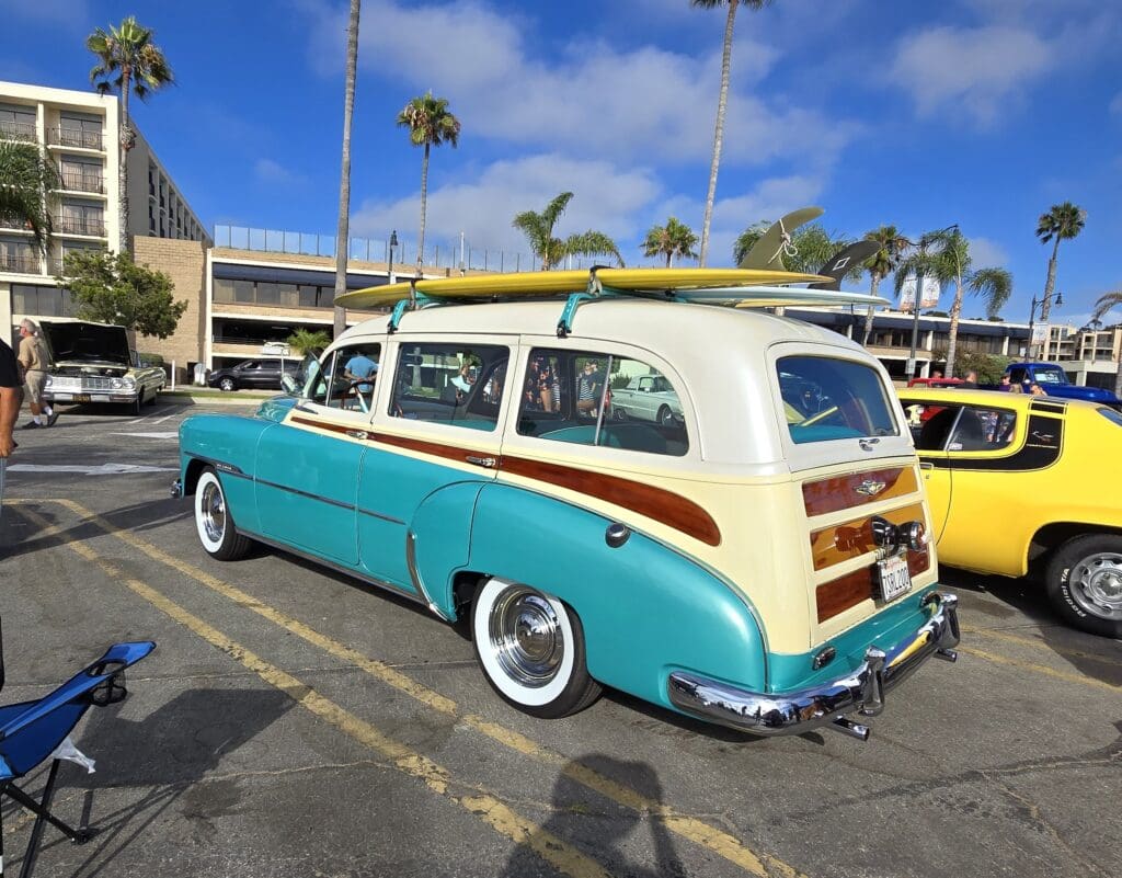 Classic turquoise and cream vintage woodie station wagon parked outdoors.