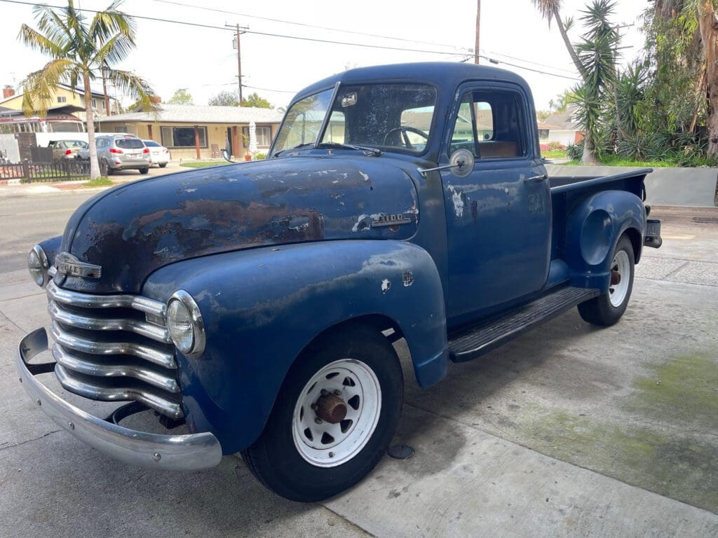 Classic blue vintage pickup truck parked outdoors.