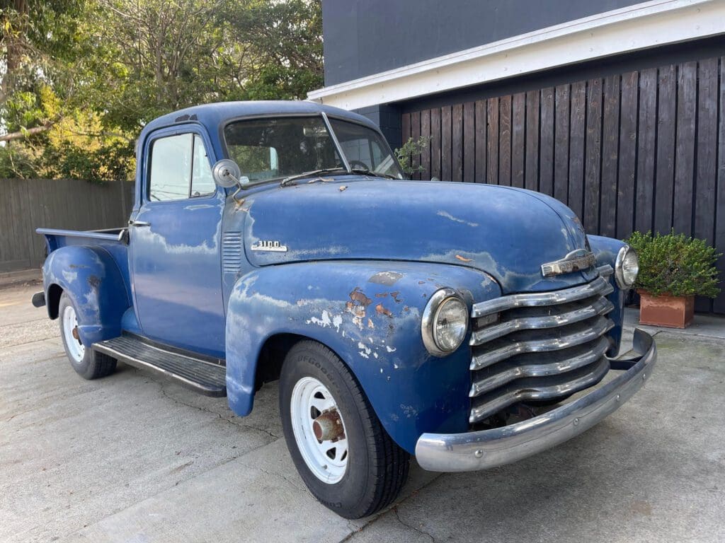 Classic blue vintage pickup truck parked outdoors.