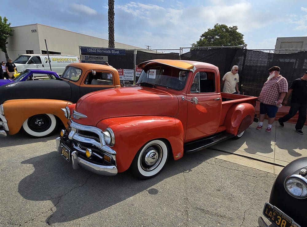Classic red vintage pickup truck at a car show.