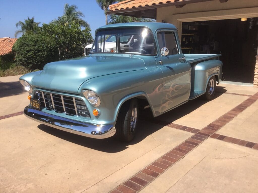 Classic blue vintage pickup truck parked in a driveway.