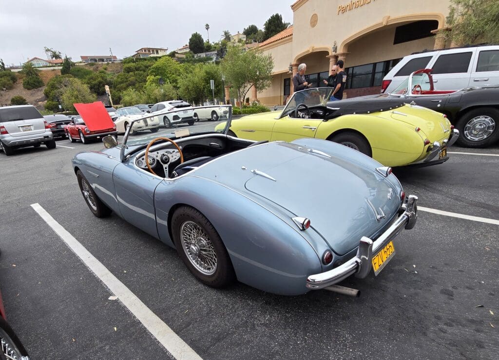 Classic light blue convertible sports car parked outdoors.
