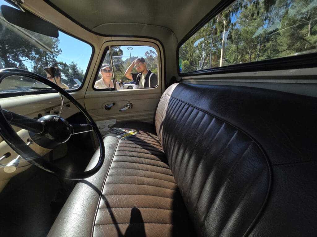 Vintage car interior with brown leather seats and steering wheel.