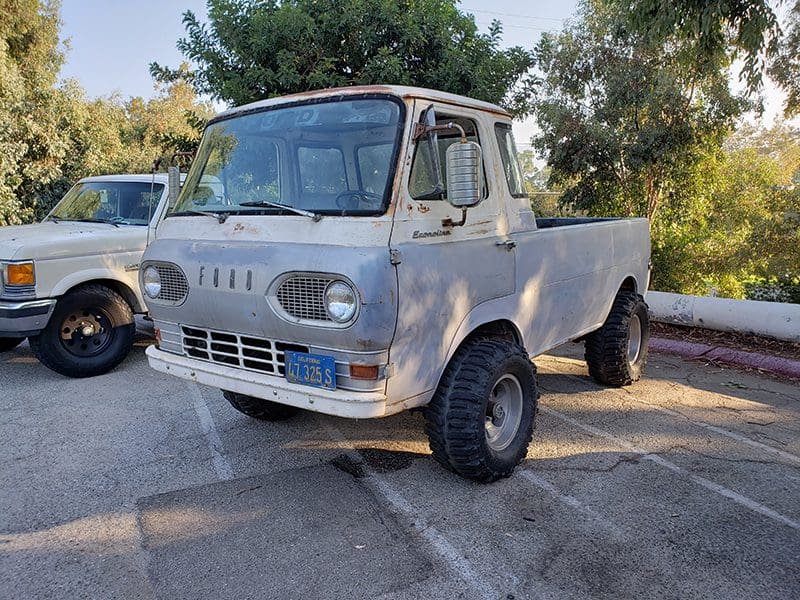 Classic white vintage pickup truck parked outdoors.
