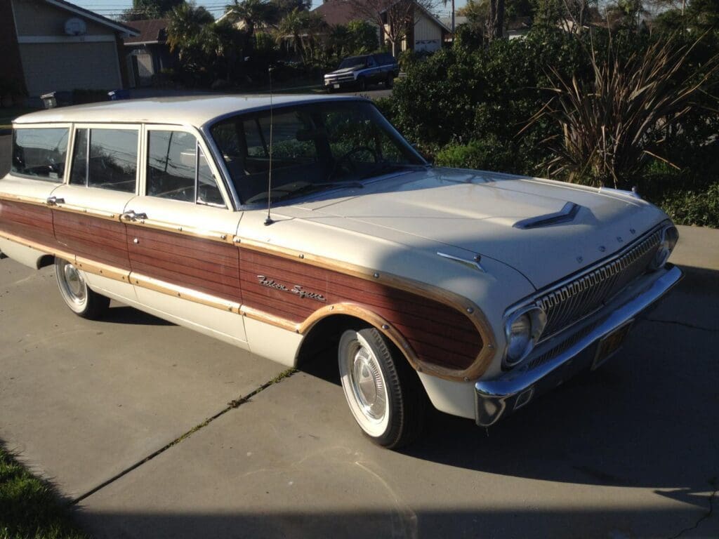 Classic white station wagon with wood paneling parked outdoors.