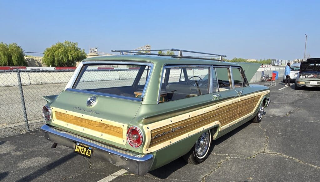 Vintage station wagon with wood paneling parked outdoors on a clear day.