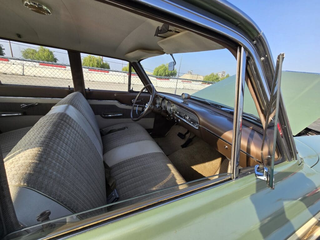 Interior view of a vintage car with bench seats and classic dashboard.