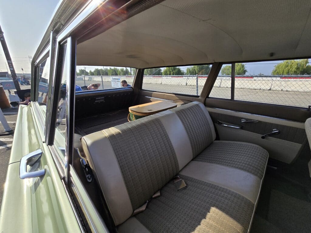 Interior view of a vintage car with gray and beige seats.