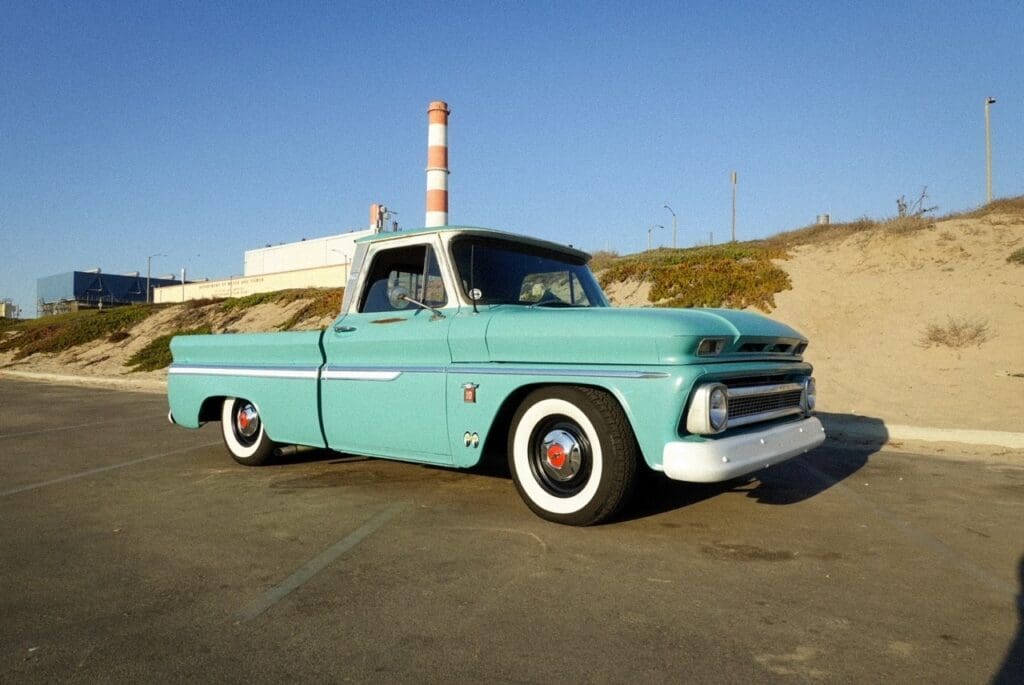 Vintage turquoise pickup truck parked on a sunny day.