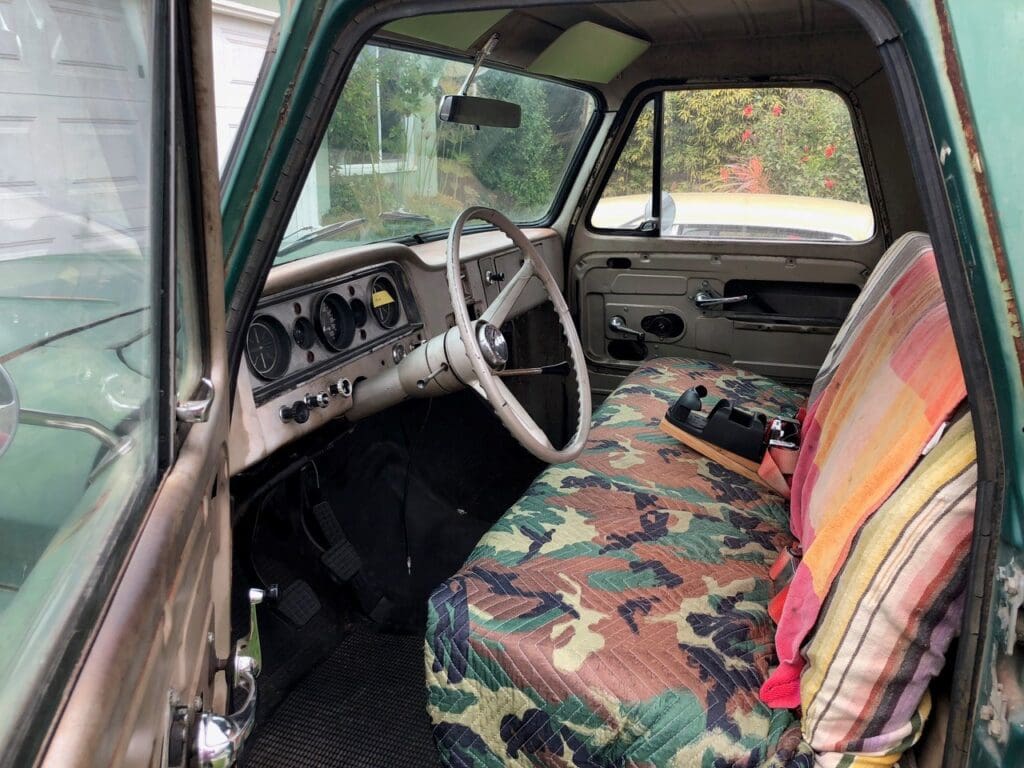 Vintage green pickup truck parked outdoors on a sunny day.