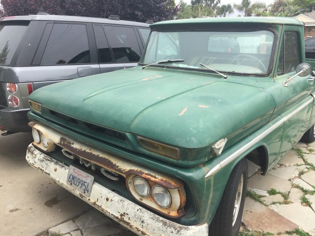 Vintage green Chevrolet truck parked outdoors with weathered paint.