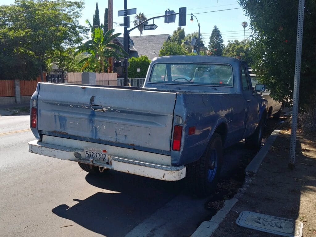 Blue vintage Chevrolet pickup truck parked on a sunny street.