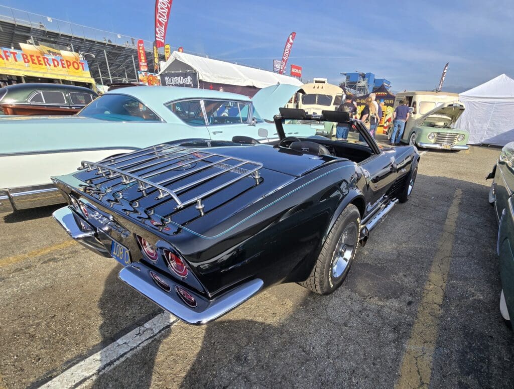 A classic black convertible car with chrome details and a luggage rack.