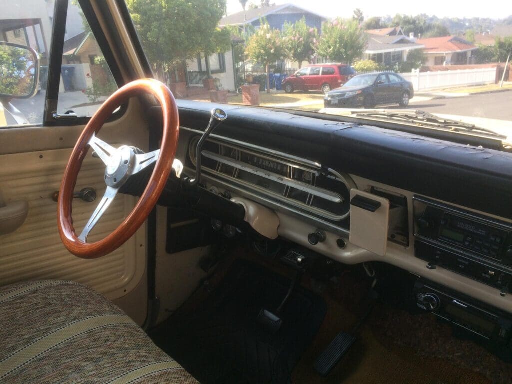 Interior view of a vintage car with a wooden steering wheel.