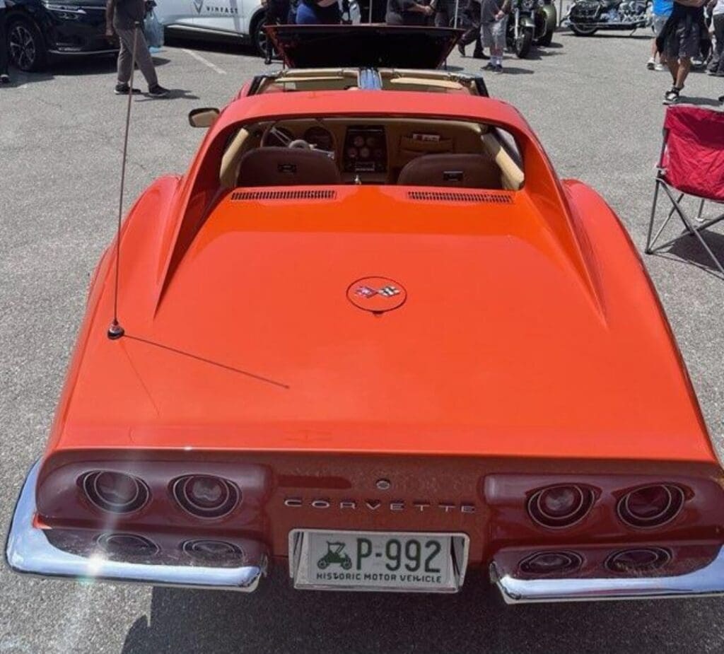 Bright orange classic sports car viewed from the rear.