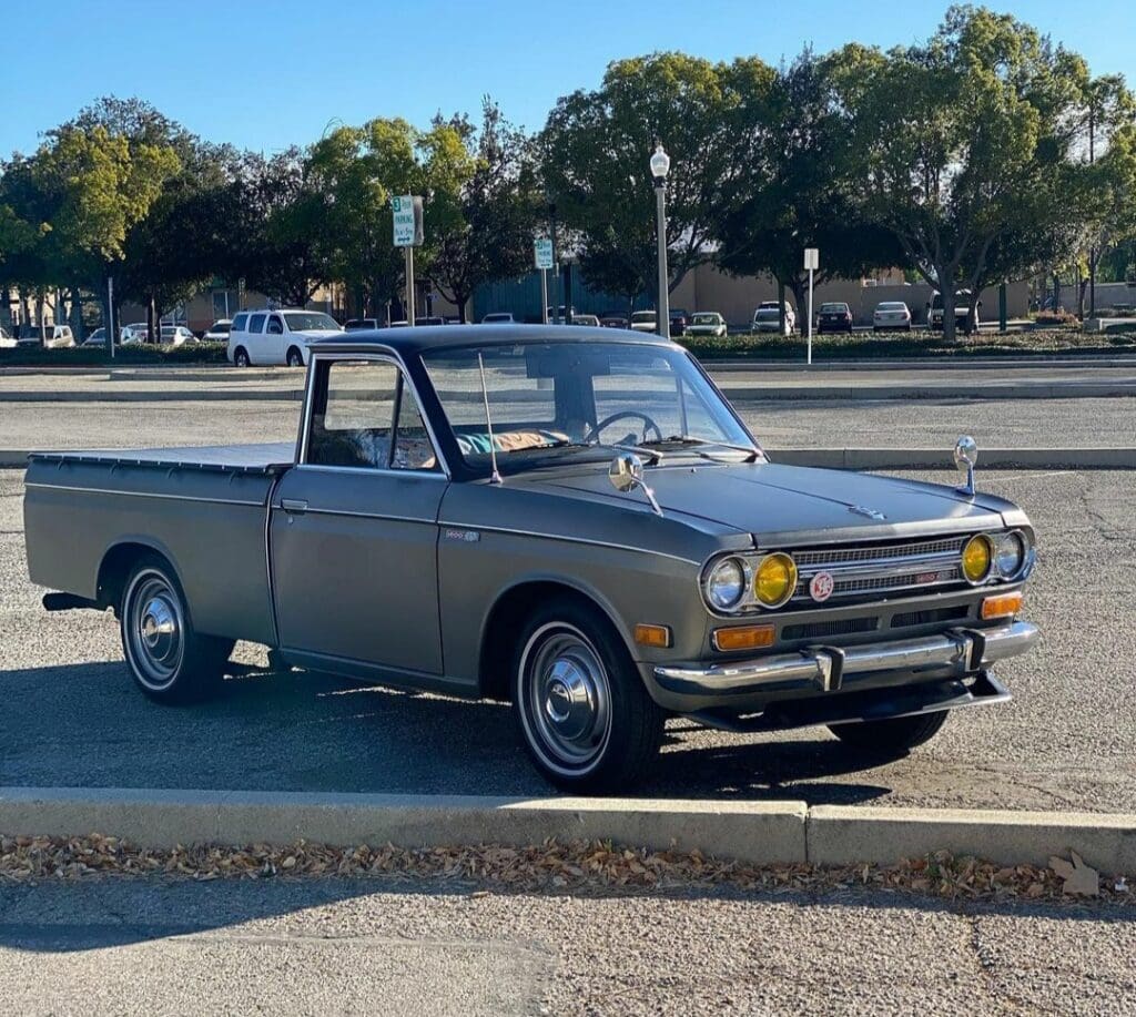 Classic gray pickup truck parked outdoors under a clear sky.