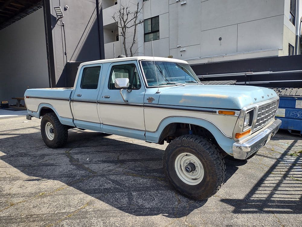 Classic light blue and white vintage pickup truck parked outdoors.