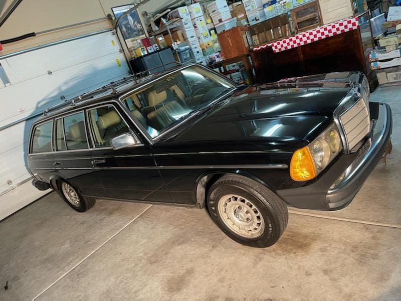 Classic black station wagon parked indoors with vintage design.