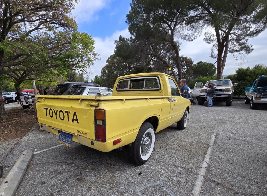 Yellow vintage Toyota pickup truck parked outdoors.