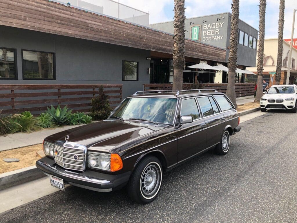 Classic brown Mercedes-Benz station wagon parked on a city street.