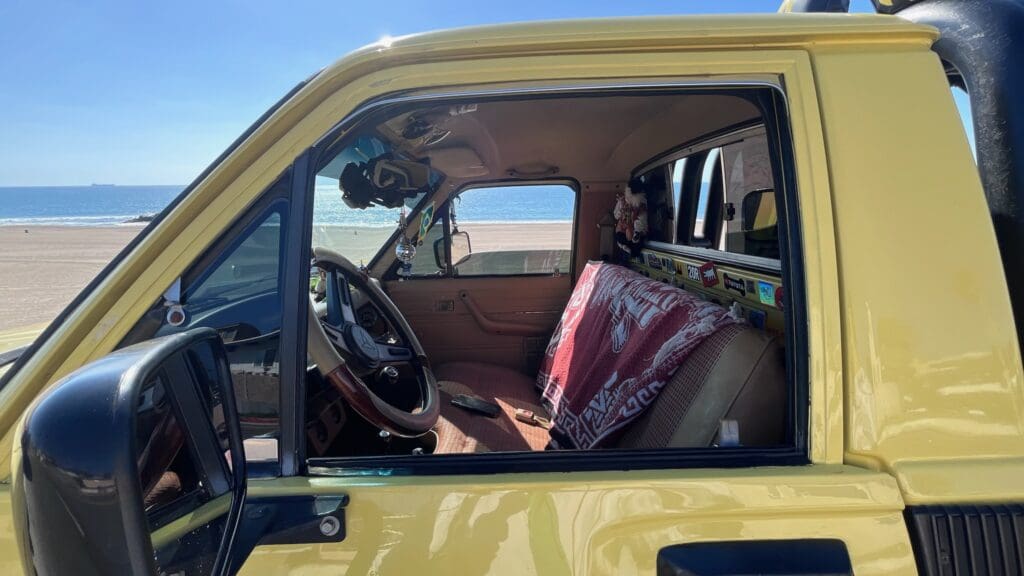 Interior view of a yellow car showing the driver's seat and steering wheel.