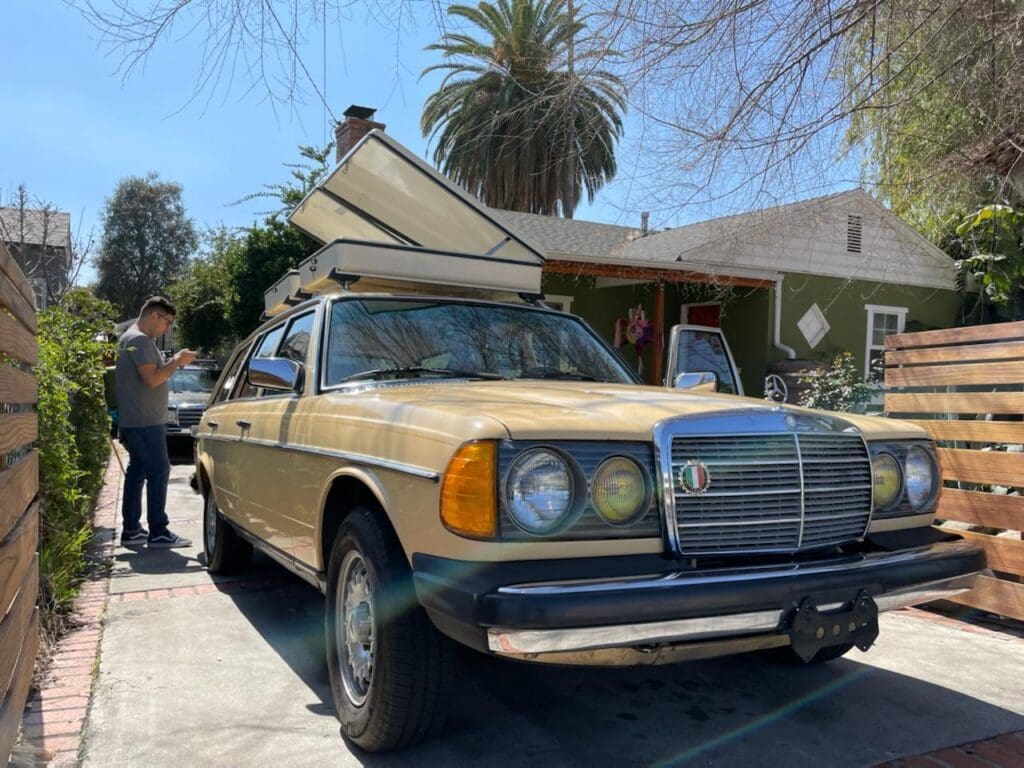 Classic yellow Mercedes-Benz car parked outdoors on a sunny day.