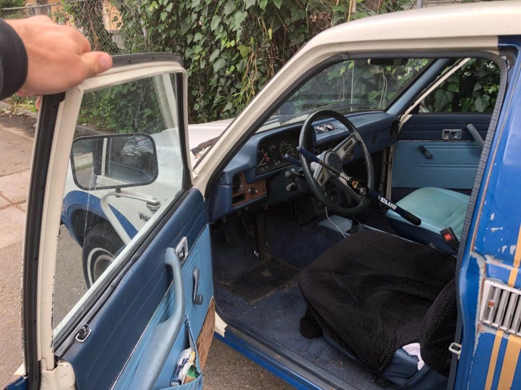 Open door showing the interior of a vintage car with blue accents.