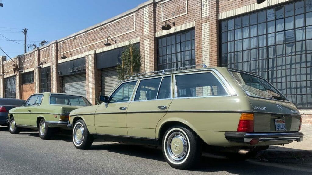 Classic beige Mercedes-Benz station wagon parked by a brick building.
