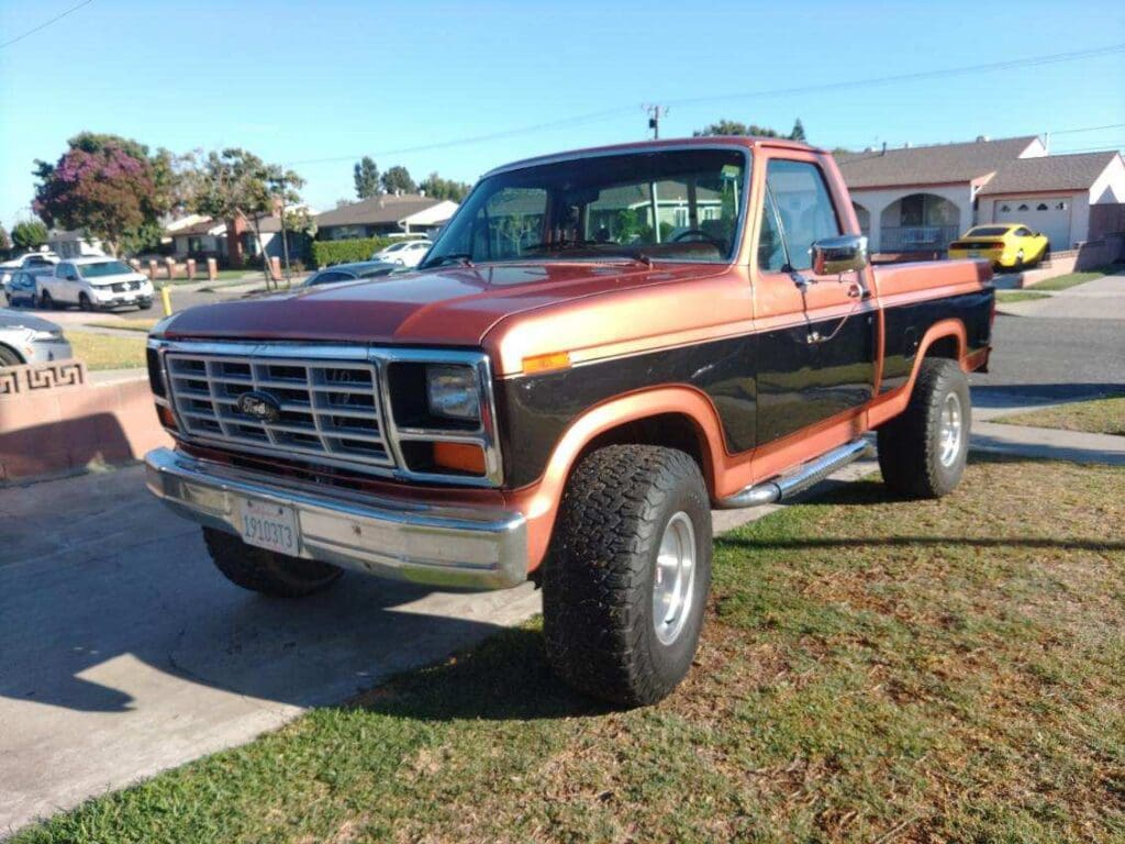 Classic two-tone pickup truck parked on a suburban street.