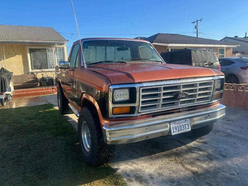 Classic brown Dodge truck parked outside in a sunny yard.