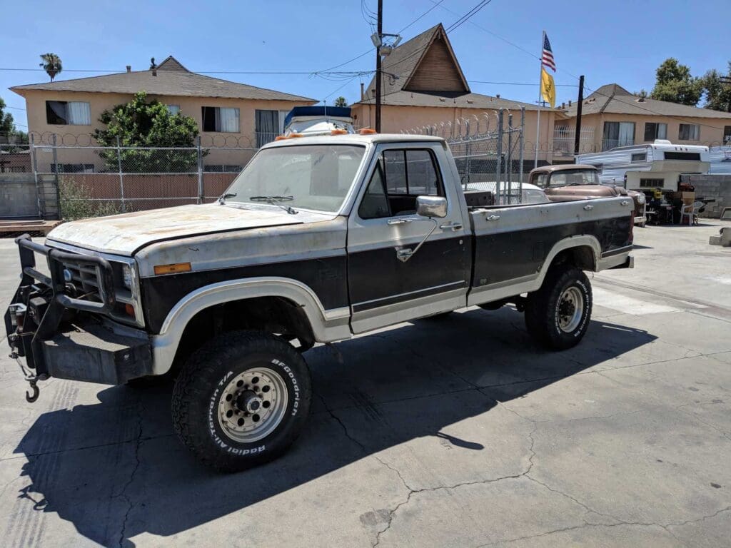 Classic black and white pickup truck parked on a sunny street.