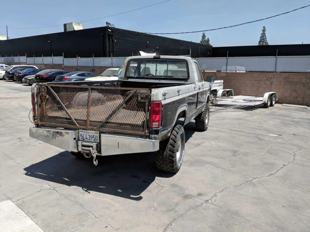 A silver pickup truck with a custom tailgate parked outdoors.