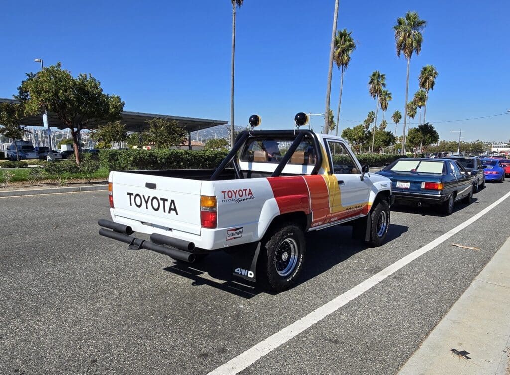 Rear view of a vintage Toyota pickup truck with a unique color scheme.