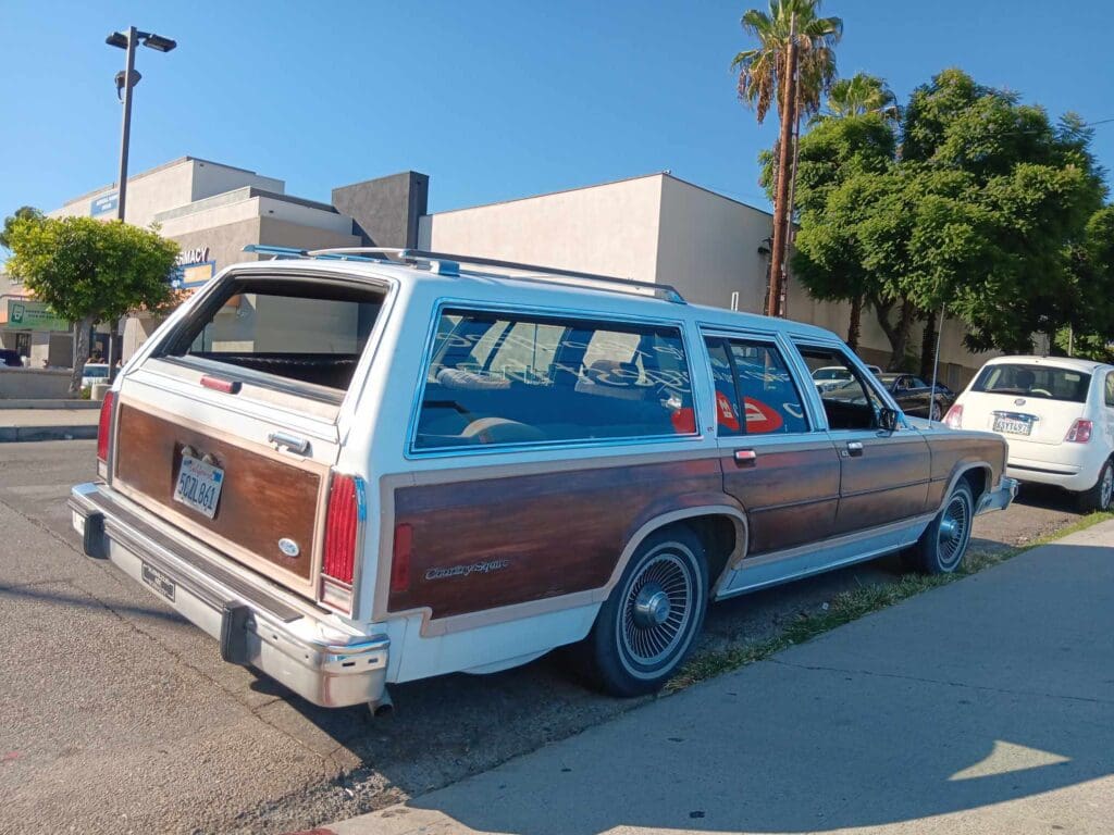 Classic wood-paneled station wagon parked on a sunny street.