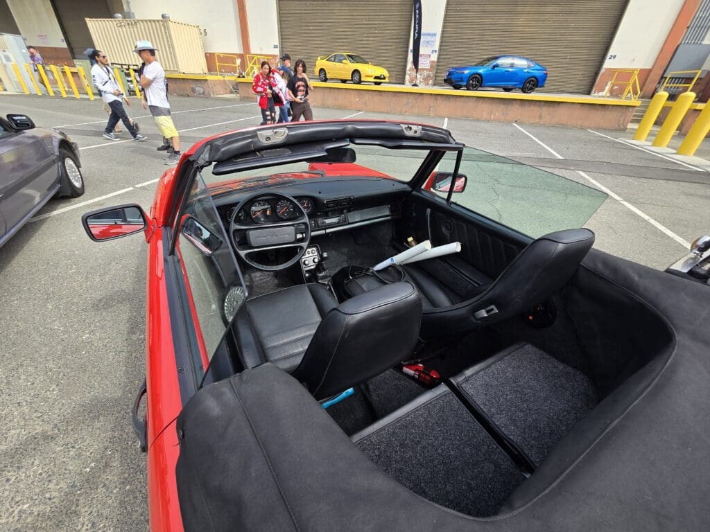 Red convertible car with modern dashboard and open roof.