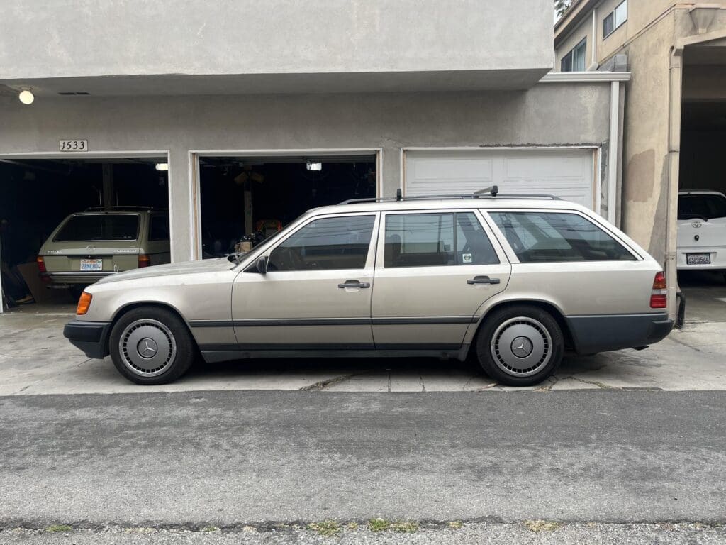 Classic beige station wagon parked on a city street.