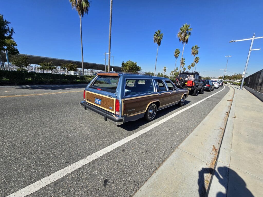 Classic wood-paneled station wagon parked on a sunny street.