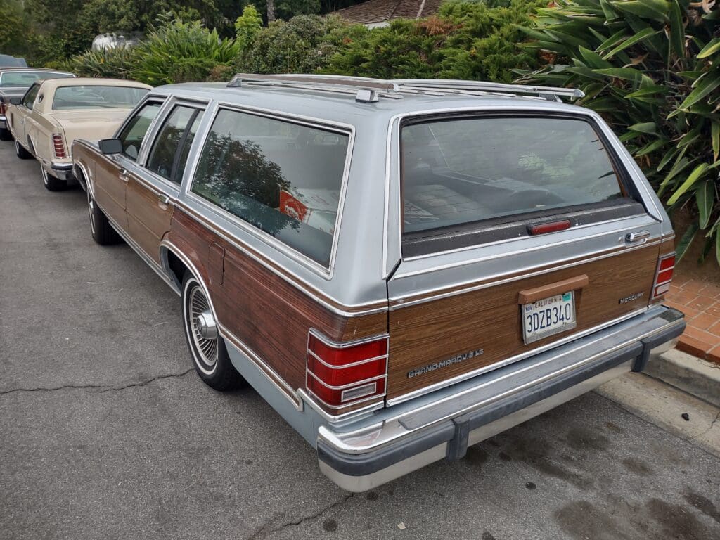 Classic station wagon with wood paneling parked on a street.