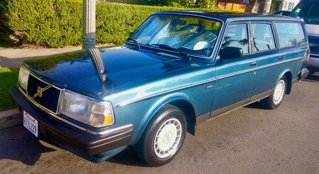 Blue vintage Volvo car parked on a sunny street.