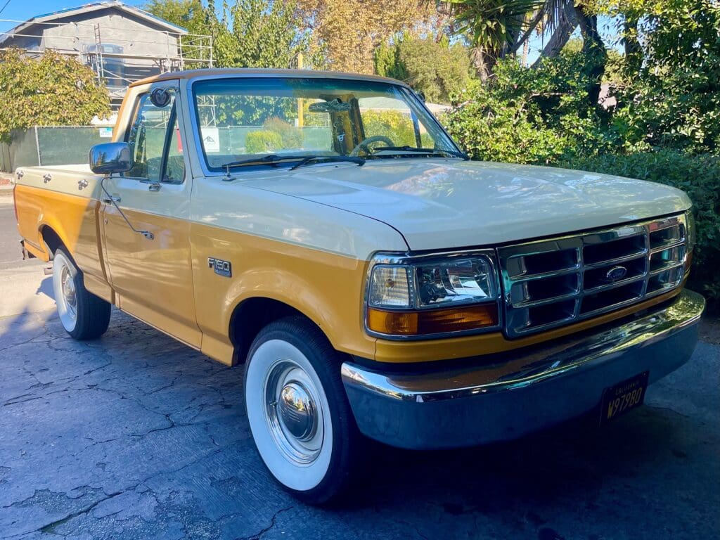 Classic beige pickup truck parked on a sunny street.
