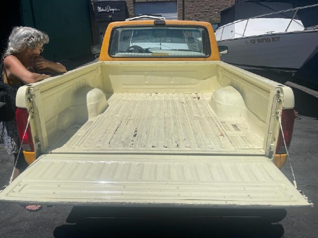 Classic beige pickup truck parked on a sunny street.