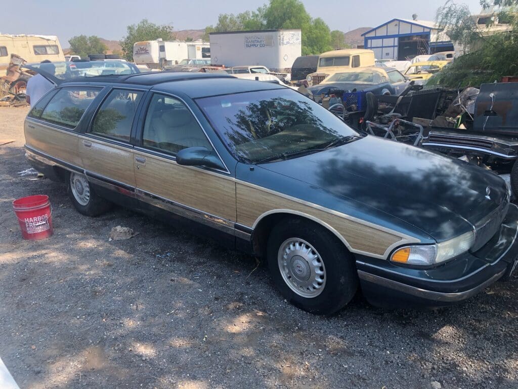A vintage two-tone station wagon parked outdoors.